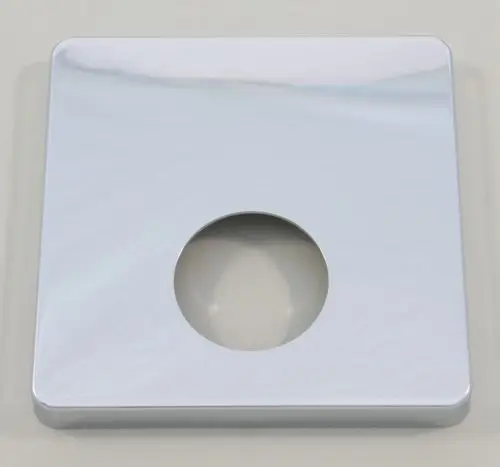 Quadratische Rosette aus Chrom, gefertigt von Ideal Standard, mit zentralem Loch. Oberfläche reflektiert Licht und hat abgerundete Kanten. Ideal für Brauseanwendungen.